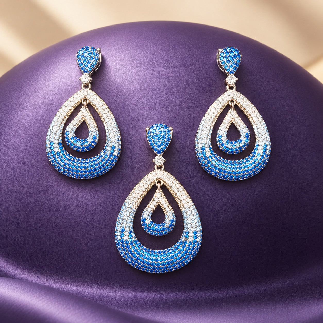 Blue and white teardrop jewellery on a purple sculptural display